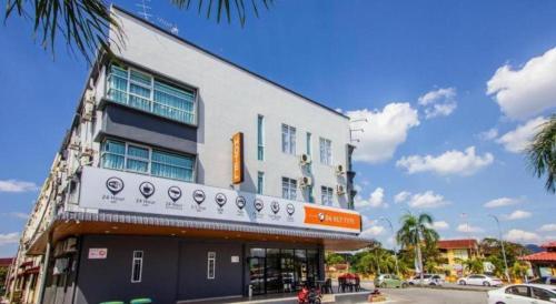 a white building with a sign on the side of it at Big Orange Hotel Jitra in Alor Setar
