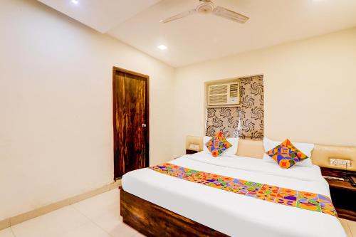 a bedroom with a large white bed with a window at FabExpress Travellers in Lucknow