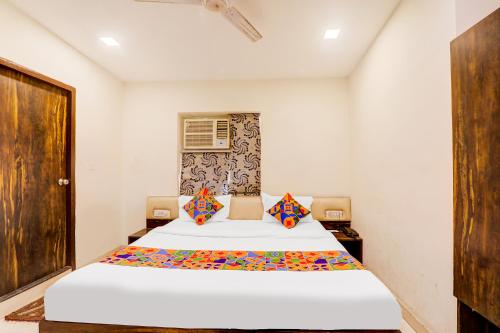 a bedroom with a bed and a door at FabExpress Travellers in Lucknow