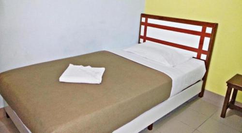 a bed with a wooden headboard and a pillow on it at Sakiza View Mersing in Mersing