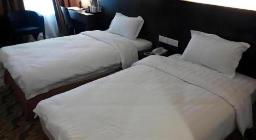 a hotel room with two beds and a phone at Eminent Hotel in Kota Kinabalu