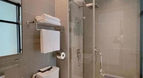 a bathroom with a shower and a toilet with a glass door at S Hotel in Johor Bahru