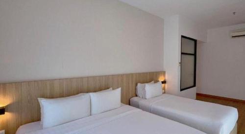 a bedroom with two beds with white pillows at S Hotel in Johor Bahru