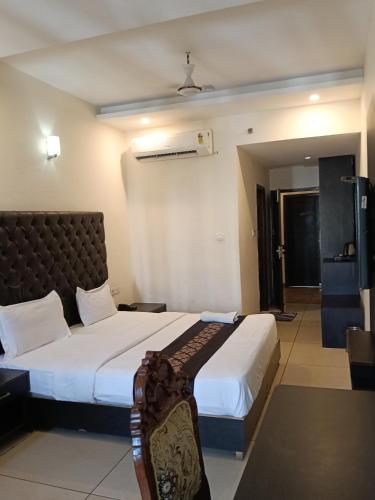 a hotel room with two beds and a chair at Hotel orbit grand in Chandīgarh