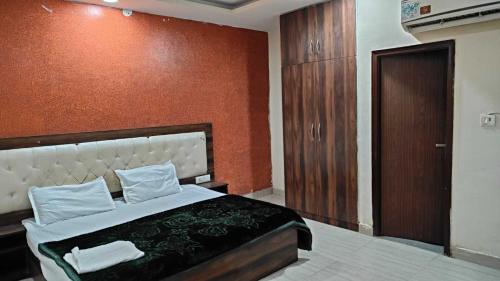 una camera da letto con un letto e una parete rossa di Hotel O Rana Guest House a Ballabgarh