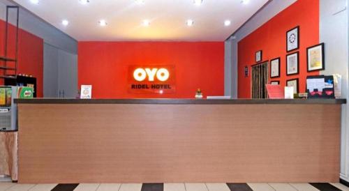a store with an omo sign on a red wall at Capital O Ridel Hotel Kota Bharu in Kota Bharu