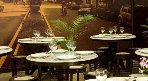 a group of tables and chairs with wine glasses at The Regency Hotel Seri Warisan in Taiping