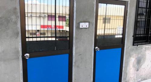 a pair of doors with blue signs on them at SPOT ON 90077 Cherry's Lodge in Lahad Datu