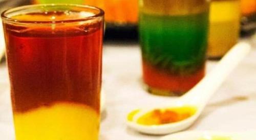 a table with two glasses of juice and a spoon at The Regency Hotel Seri Warisan in Taiping