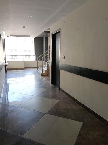 an empty hallway with a door and a tile floor at Hotel orbit grand in Chandīgarh