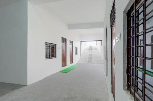 a hallway with white walls and a green carpet at SPOT ON Hotel Veer Galaxy in Ghātampur