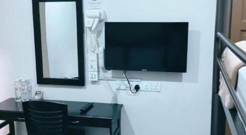 a tv on a wall in a room with a desk at Power Hotel in Georgetown