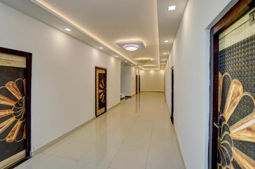 a long hallway with paintings on the walls at Spot On THE RAJA GRAND in Akbarpur
