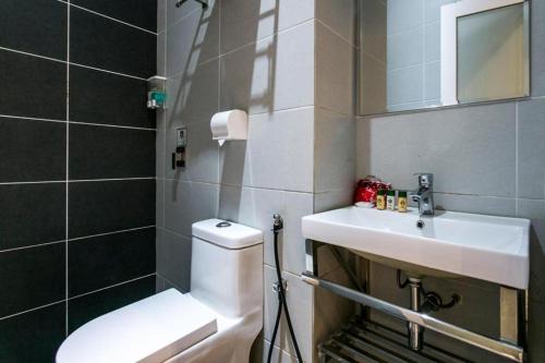 une salle de bain avec des toilettes blanches et un lavabo dans l'établissement OYO 288 Sri Enstek Hotel, à Sepang