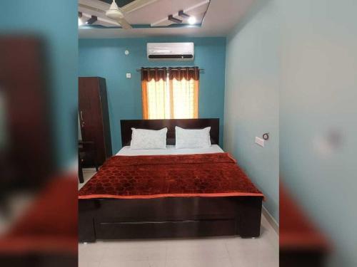 a bedroom with a bed with a red comforter and a window at Hotel O Shrihaan Residency in Rāmachandrapuram