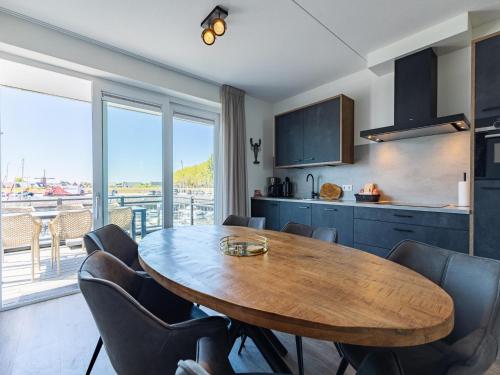 a kitchen with a wooden table and some chairs at Unique apartment, located on the Oosterschelde and marina of Sint Annaland in Sint Annaland