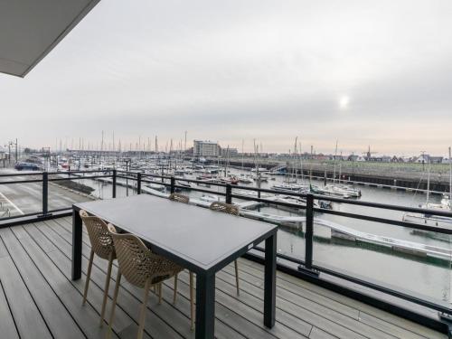 a table and chairs on a balcony with a marina at Unique apartment, located on the Oosterschelde and marina of Sint Annaland in Sint Annaland