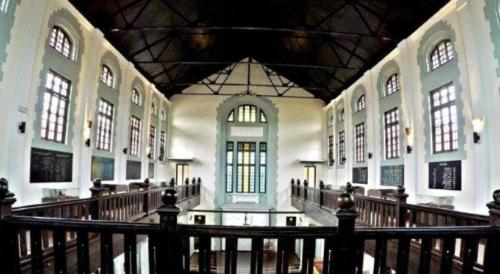 a large building with a hallway with windows and a staircase at Twin Star Hotel in Tanjung Malim