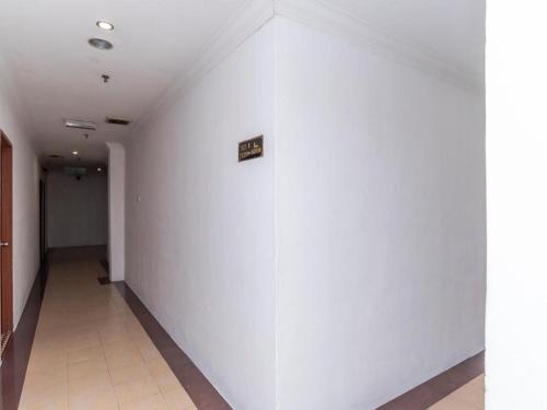 a hallway with white walls and a sign on a wall at Super OYO 1114 Neo Pegasus Hotel in Segamat