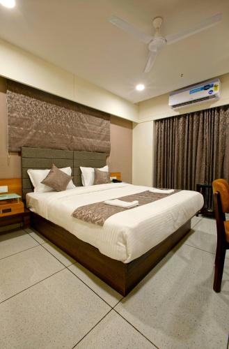 a bedroom with a large bed in a room at HOTEL AURELLIA in Sarkhej