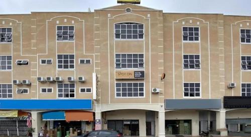 a large building with a car parked in front of it at SPOT ON 91178 Motel Impian in Seri Manjung