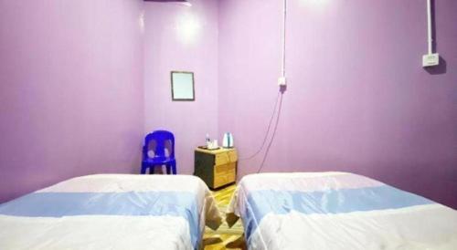 a hospital room with two beds and a blue chair at SPOT ON 89986 P&p Inn in Kota Kinabalu