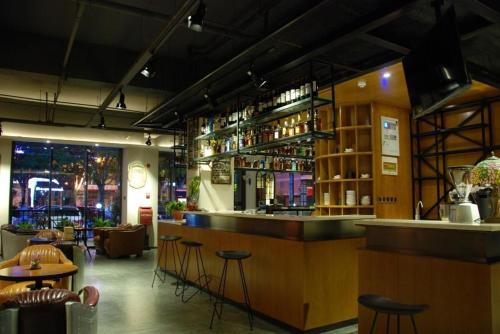 a bar in a restaurant with bar stools at James Joyce Coffetel Xian Big Goose Pagoda Tang Paradise Branch in Xi'an