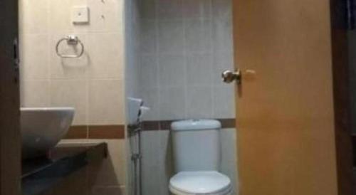a bathroom with a white toilet and a sink at Grand Barakah Hotel in Kuala Lumpur