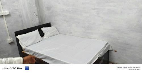 een klein bed met witte lakens en kussens in een kamer bij SPOT ON HM HOTEL in Mundarwa