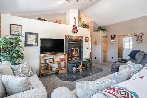 un soggiorno con camino e TV di Cozy Mountain Cabin in Idaho Springs a Saint Marys