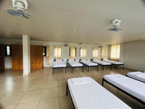 a room with a row of beds in a room at Regalia Wayanad in Kalpetta