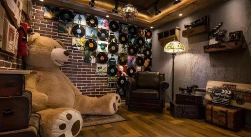 a room with a large teddy bear and a brick wall at James Joyce Coffetel·Kaifeng Drum Tower in Kaifeng