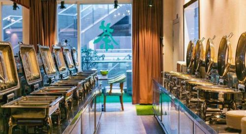 a row of tables and chairs in a restaurant at James Joyce Coffetel Chengdou Wuqing Wanda Plaza in Chengdu