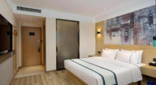 a hotel room with a large white bed and a television at City Comfort Inn Ji'an South Administrative Center in Ji'an
