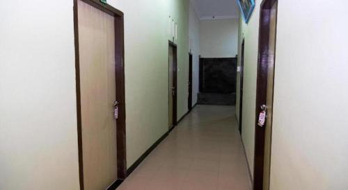 an empty hallway with doors and a hallwayngthngthngthngthngthngthngthngth at Hotel O Abz Guest House Syariah in Jambi
