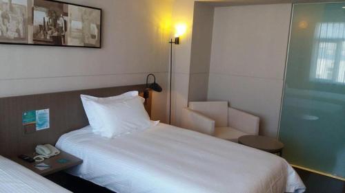 a hotel room with a bed and a chair at Jinjiang Inn Select Beijing Miyun Development Zone in Miyun