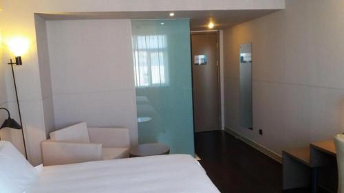 a room with a bed and a chair and a glass door at Jinjiang Inn Select Beijing Miyun Development Zone in Miyun
