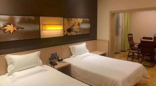 a hotel room with two beds with white sheets at IU Hotel Taiyuan Changfeng West Street The Mixc in Taiyuan