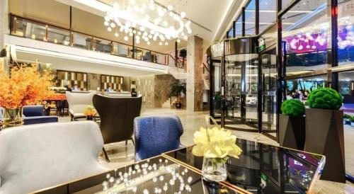 a lobby of a hotel with chairs and tables at Echarm Hotel Guizhou Xingyi Jushan Avenue in Xiawutun