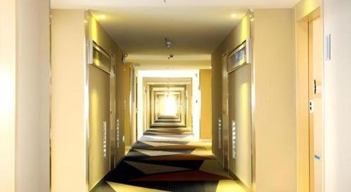 a hallway with a long aisle with towels at City Comfort Inn Qianjiang Longxiacheng in Qianjiang
