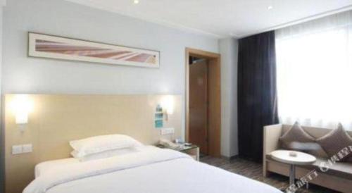 a hotel room with a bed and a couch at City Comfort Inn Qianjiang Longxiacheng in Qianjiang