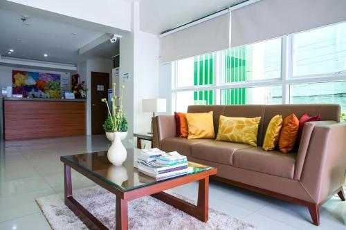 a living room with a couch and a coffee table at Hotel Fleur de Liz in Panglao