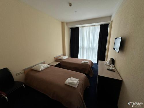 a hotel room with two beds and a window at Rustaveli Inn რუსთაველი ინნ in Rustavi