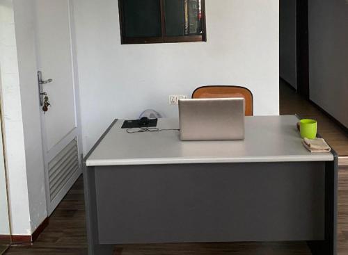 a desk with a laptop computer on top of it at Hotel O Wisma Pinggir in Tanjung Pinang 