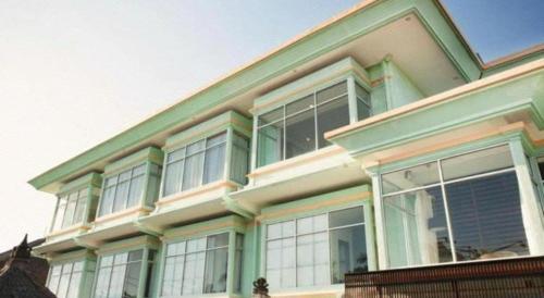 a house with green trim and large windows at The Studio Inn Nusa Dua in Ubud