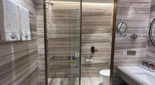 a bathroom with a shower with a toilet and a sink at Zhuhai Hongsanyi Hotel in Zhuhai