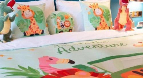 a birthday cake with giraffe pillows on a bed at Zhuhai Hongsanyi Hotel in Zhuhai