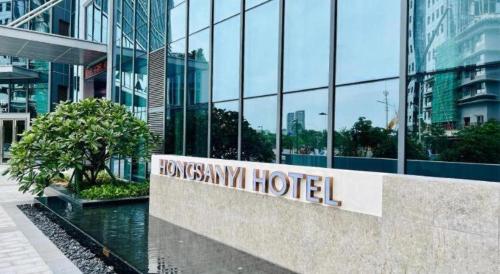a hotel sign in front of a glass building at Zhuhai Hongsanyi Hotel in Zhuhai