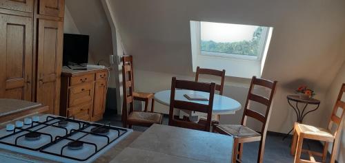 a kitchen with a stove and a table and a window at L hirondelle in Beaumont-le-Hareng