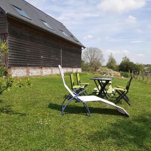 two lawn chairs and a table in a yard at L hirondelle in Beaumont-le-Hareng